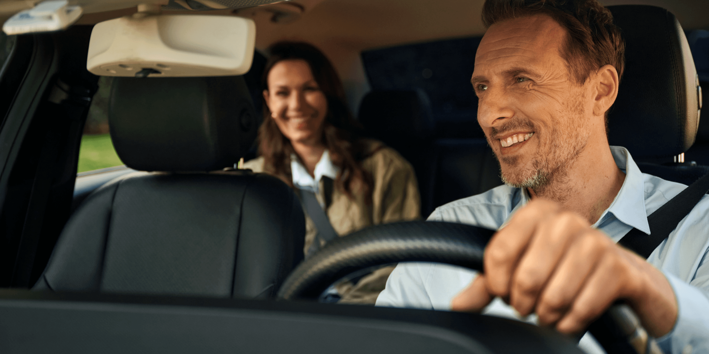 Mitarbeiter sitzt im Auto und schaut auf sein Handy, nachdem er mit seinem FREENOW-Mobilitätsbudget kontaktlos getankt hat