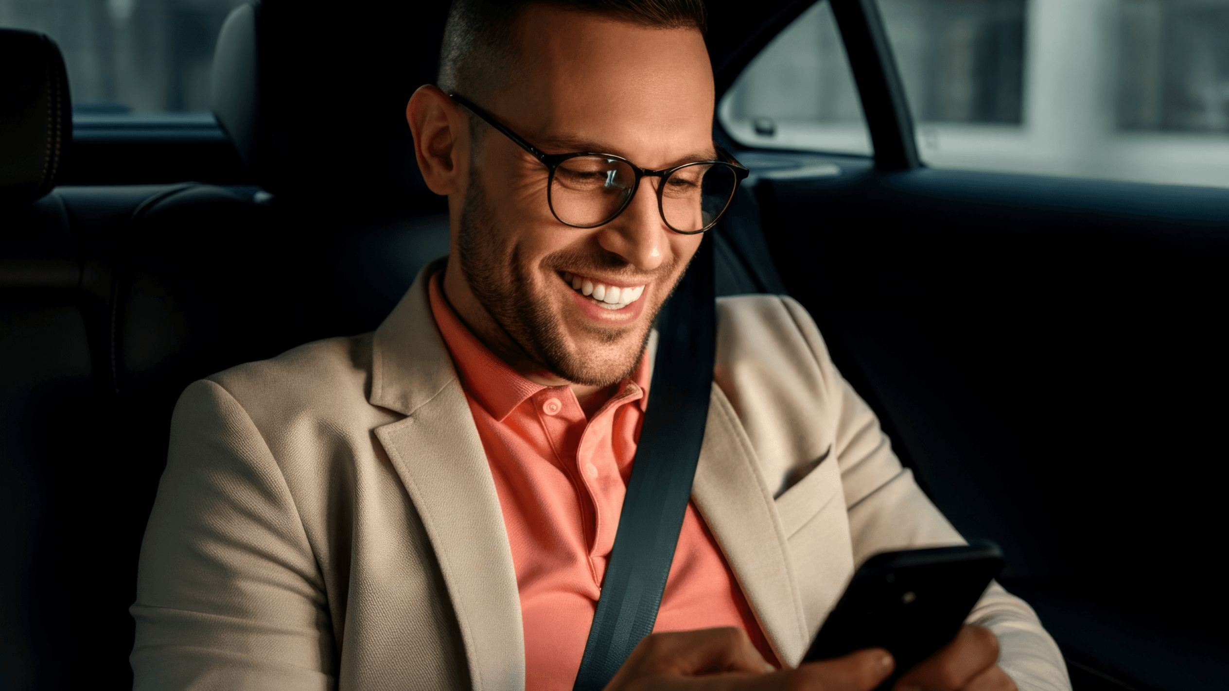 Taxi drivers hands on car wheel with mobile phone in holder with the FREENOW logo on the screen and an icon with coins popping out.