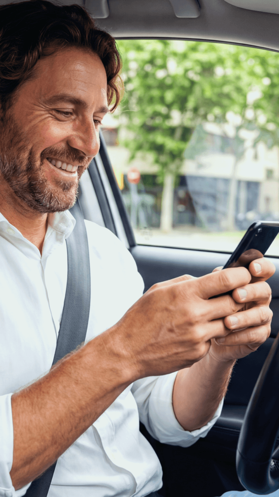 driver sitting in taxi holding phone