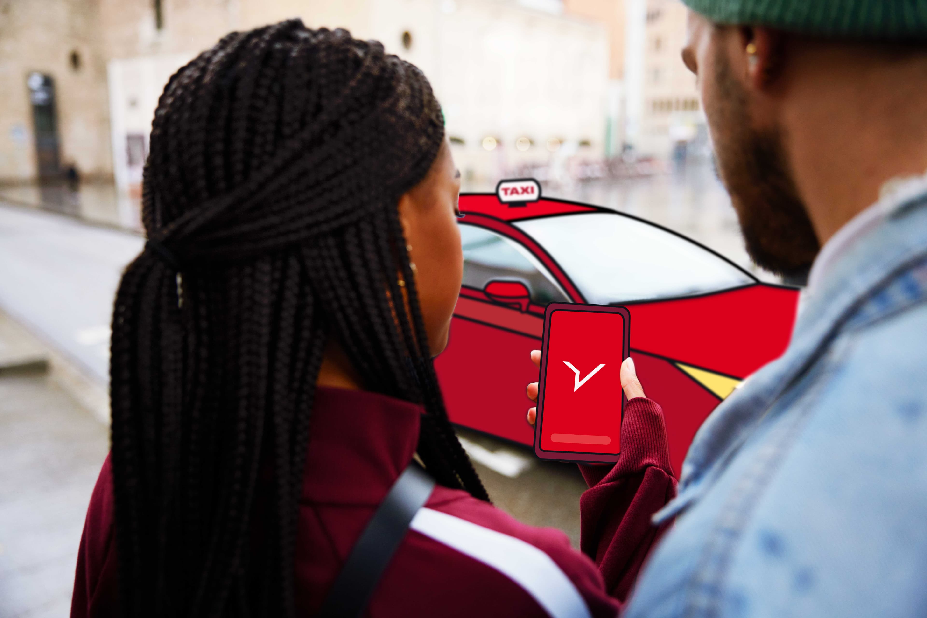 Zwei Angestellte schauen auf ein Telefon mit einem FREENOW-Logo auf dem Bildschirm und einem roten Taxi im Hintergrund