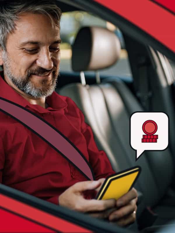 Man driving, looking at his phone