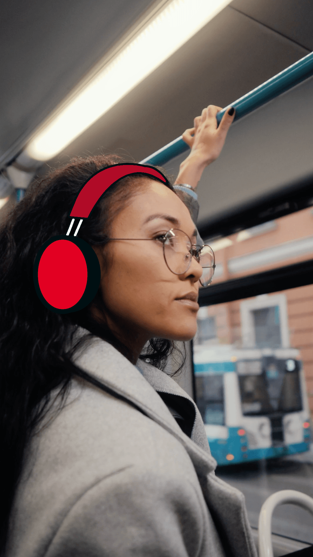 Employee with red headphones looking out of window of bus