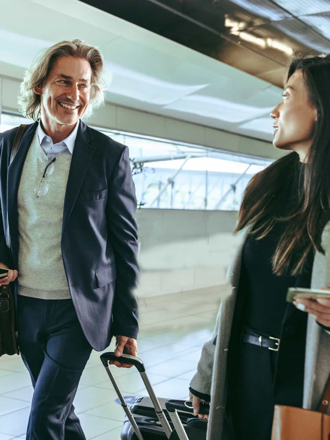 three travelers with luggage in an airport