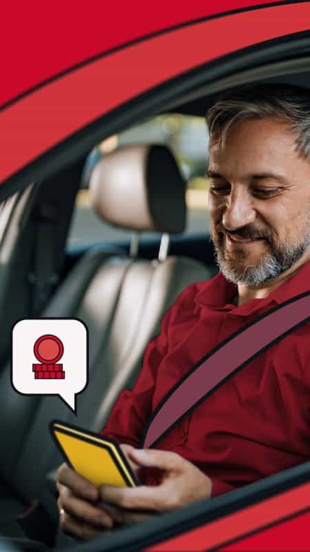 Man driving, looking at his phone